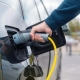 Persona conectando un cargador a un auto eléctrico en una estación de carga, representando el crecimiento de la electromovilidad en México