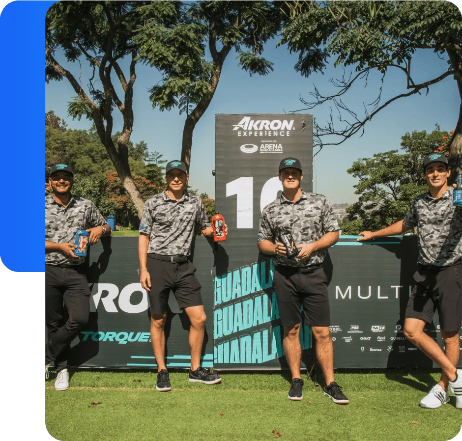 Four golf players holding Akron products in front of Akron Experience event signage in Guadalajara.