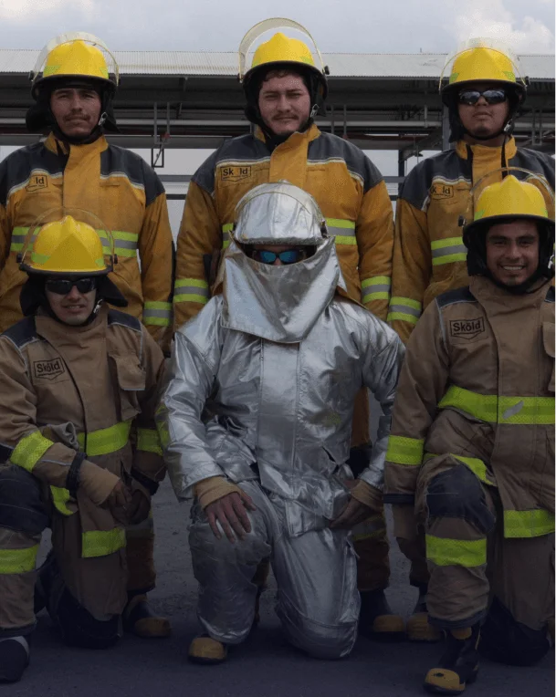 Equipo de especialistas con equipo de protección personal completo en sitio industrial.