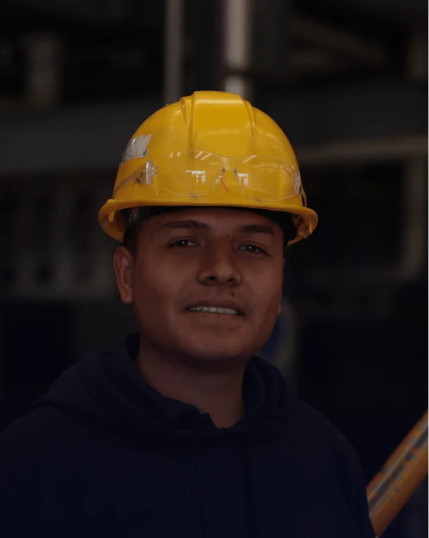 Retrato de trabajador industrial con casco amarillo de seguridad.