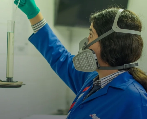 Técnica Akron con equipo de protección realizando procedimiento en laboratorio.