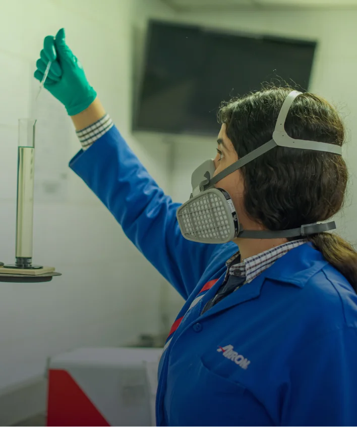 Técnica Akron con equipo de protección realizando procedimiento en laboratorio.