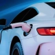 auto con enfoque en primer plano siendo cargado mediante conector elétrico