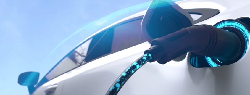 auto con enfoque en primer plano siendo cargado mediante conector elétrico